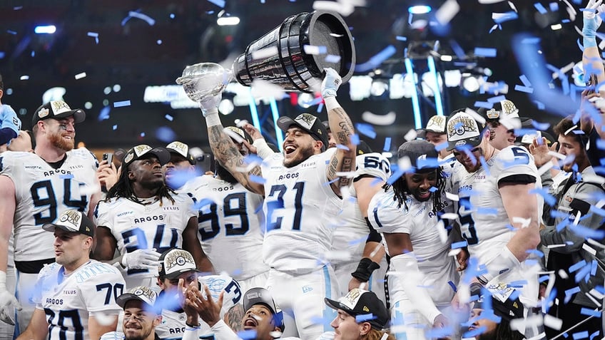 Daniel Adeboboye lifts the Grey Cup