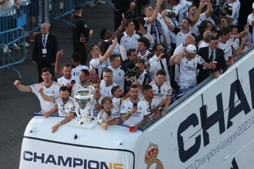 Real Madrid players parade the Champions League trophy on an open top bus after they won i