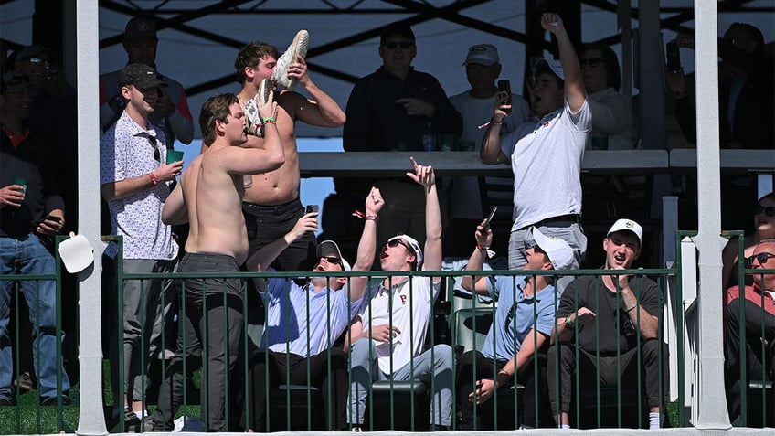 Golf fans drink beer from their shoes