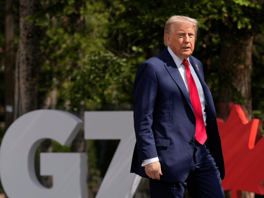 President Donald Trump walks during the official welcome of the G7 Summit, Monday, June 16