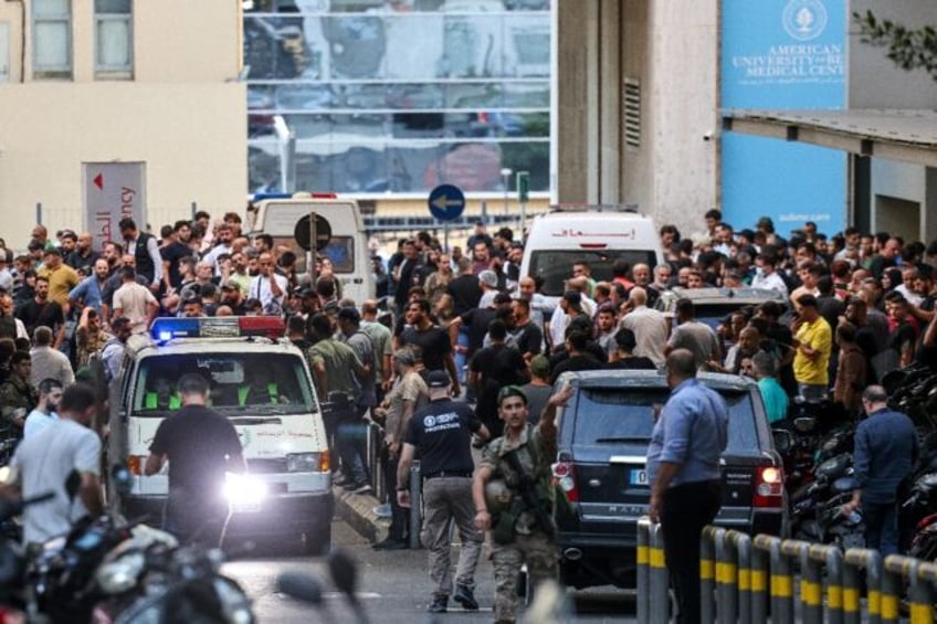 Ambulances surrounded by a crowd of people outside a Beirut hospital, in the aftermath of