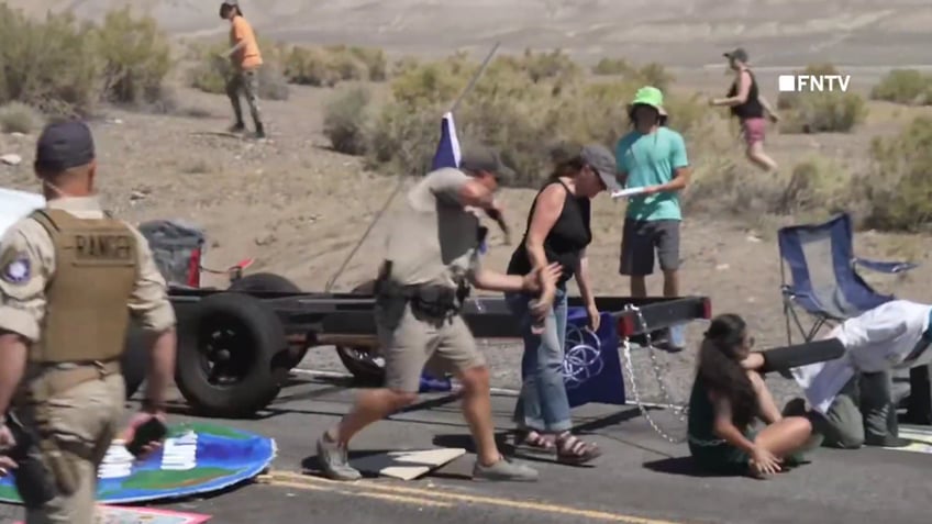 chaotic video shows police breaking up burning man climate protest blocking road and causing traffic jam