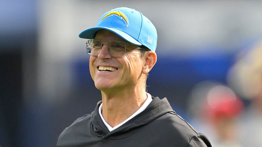 Jim Harbaugh smiles on field