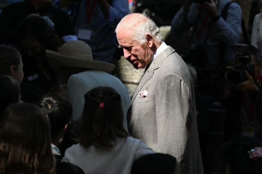 Britain's King Charles III speaks to children as he arrives to attend a Sunday morning ser