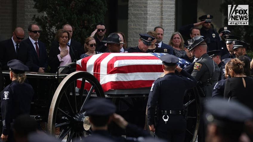 Police untie a coffin from the hearse