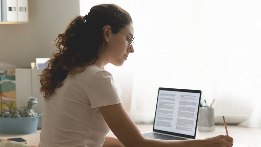 Woman writing essay on computer