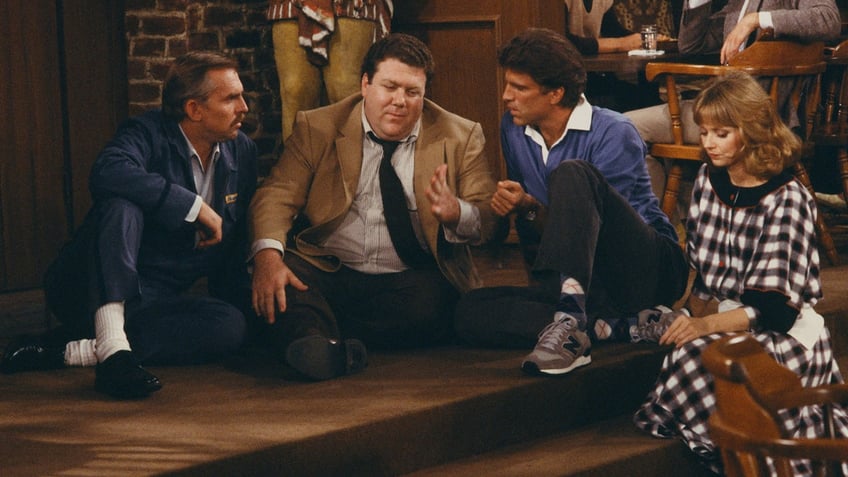 The cast of Cheers sits on the floor