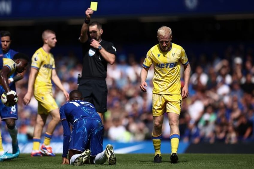 Crystal Palace midfielder Will Hughes (R) is shown a yellow card by referee Jarred Gillett