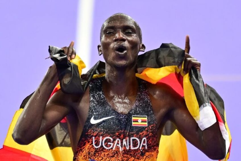 Uganda's Joshua Cheptegei celebrates victory in the men's 10,000m