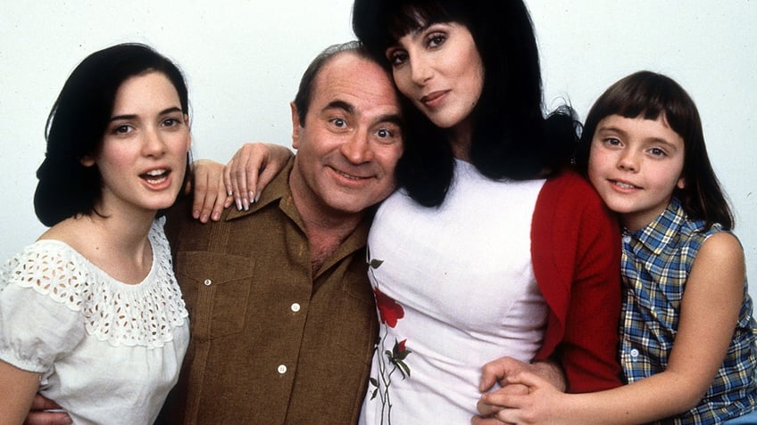 Winona Ryder in a t-shirt, Bob Hoskins in a button-down, Cher in a white top, and Christina Ricci in a plaid top pose for promotional shot for their movie, "Mermaids"