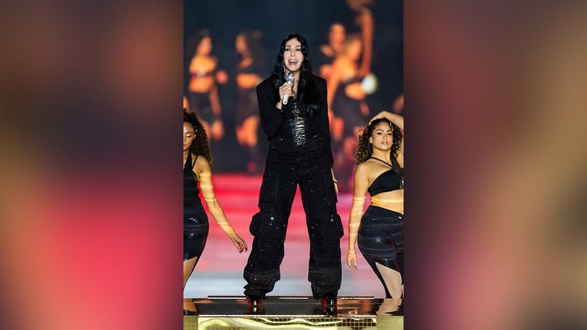 Cher performed on the runway in glittery oversized cargo pants and a revealing corset top.