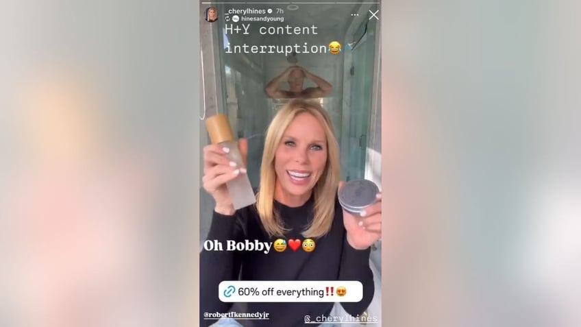 cheryl hines holds up products with rfk in shower in background