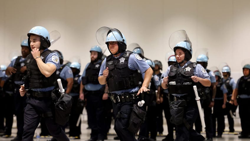 Police officers run in formation