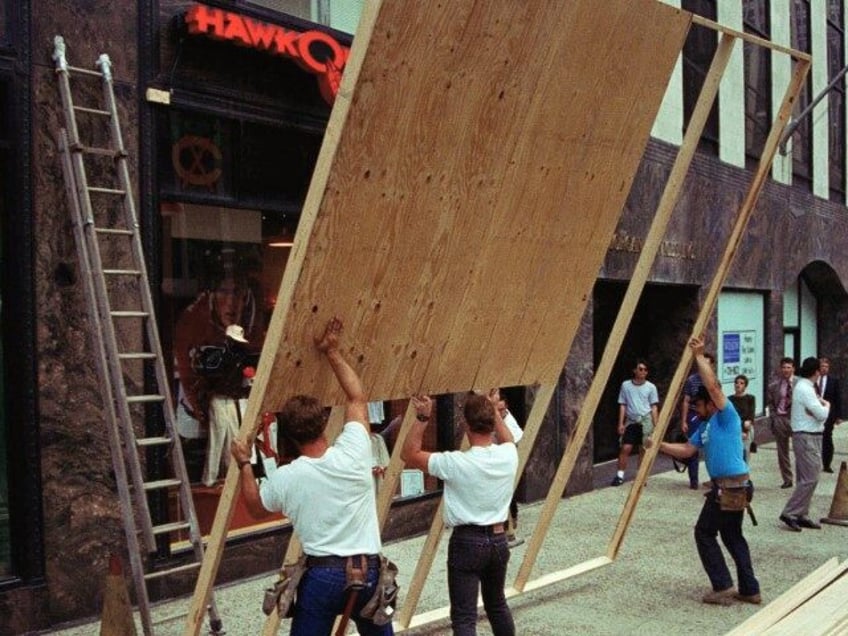 Workers board up Hawkquarters, a sports souvenir shop, on Michigan Ave. in downtown Chicag