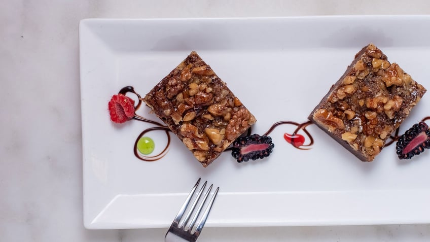 A pair of Palmer House brownies are ornately displayed on a white plate.