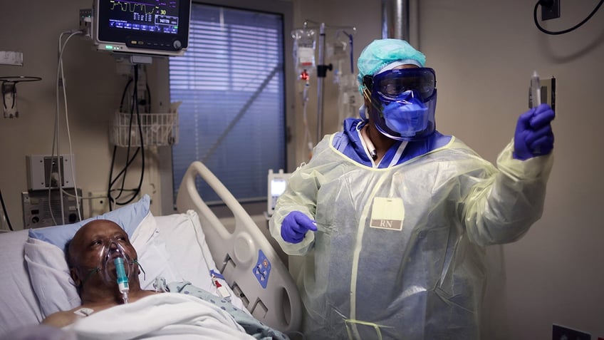 a chicago nurse tends to a covid-19 patient in hospital