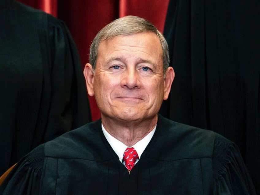 Chief Justice John Roberts sits during a group photo at the Supreme Court in Washington, F