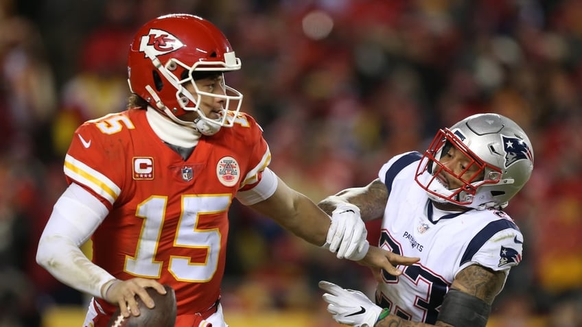 Kansas City Chiefs quarterback Patrick Mahomes, #15, stiff arms New England Patriots strong safety Patrick Chung, #23, as he rolls out in the third quarter of the AFC Championship Game between the New England Patriots and Kansas City Chiefs on Jan. 20, 2019 at Arrowhead Stadium.