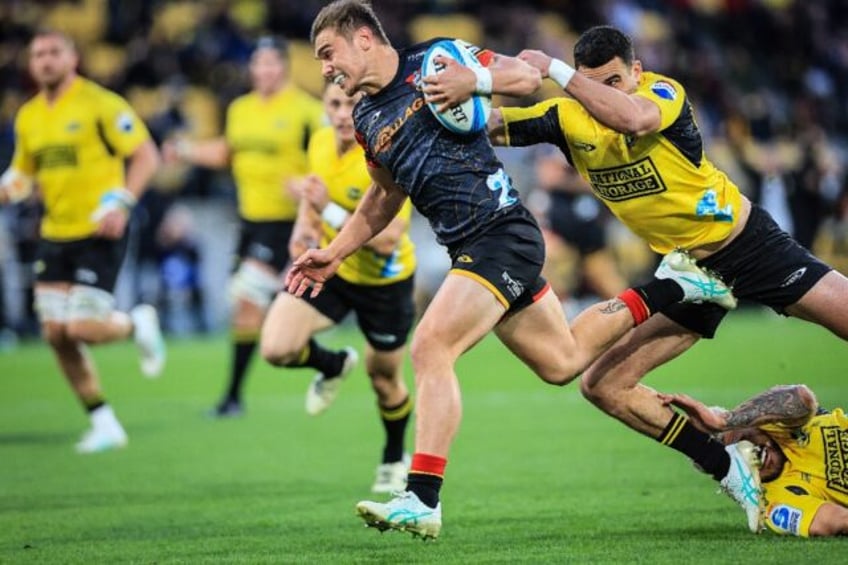 Chiefs scrum half Cortez Ratima evades a tackle from the Hurricanes Josh Moorby during the