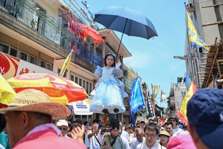 A girl participates in the "Piu Sik" parade during its annual Bun festival in Hong Kong on