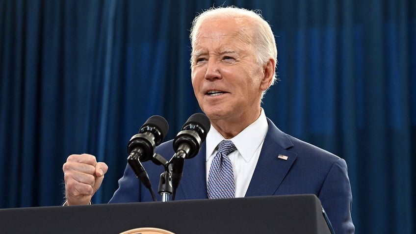 Joe Biden talking at podium, making a fist