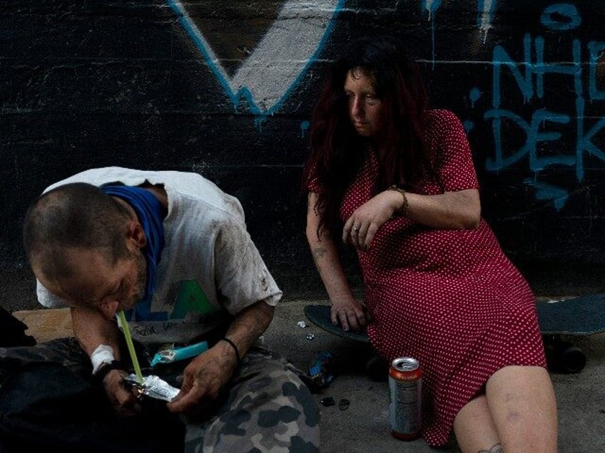 Jenn Bennett, who is high on fentanyl, sits on her skateboard with a visible black eye as