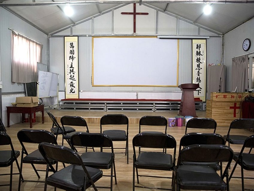 In this photo taken Monday, June 4, 2018, Chinese calligraphy which reads "All nations belong to the Lord arising to shine" at left and "Jesus's salvation spreads to the whole world" at right are displayed below a crucifix in a house church shut down by authorities near the city of Nanyang in central China's Henan province. Under President Xi Jinping, China's most powerful leader since Mao Zedong, believers are seeing their freedoms shrink dramatically even as the country undergoes a religious revival. Experts and activists say that as he consolidates his power, Xi is waging the most severe systematic suppression of Christianity in the country since religious freedom was written into the Chinese constitution in 1982. (AP Photo/Ng Han Guan)