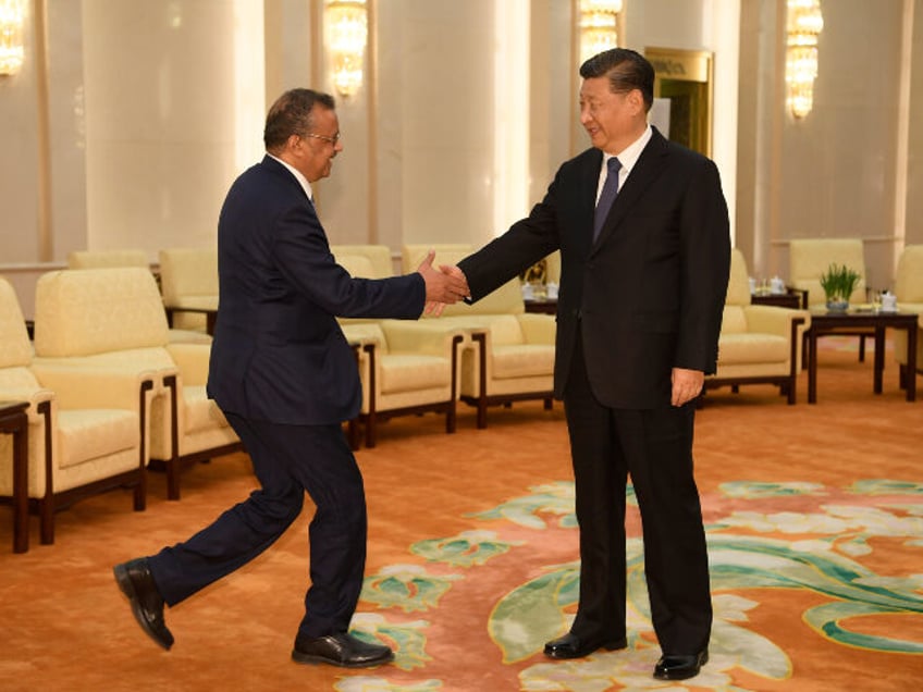 Tedros Adhanom, Director General of the World Health Organization, (L) shakes hands with C