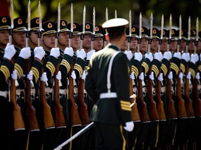 A Chinese People's Liberation Army soldier watches the position of members of a guard