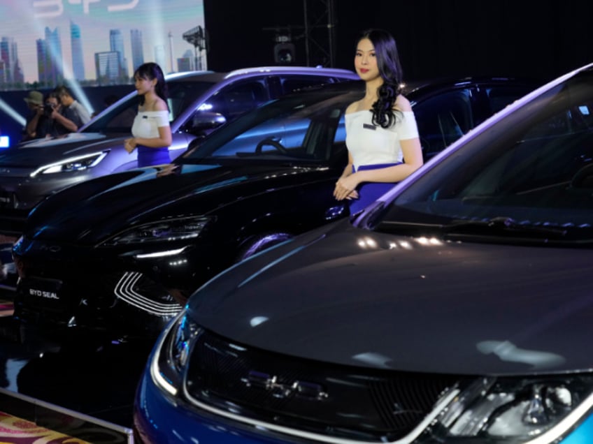 Models stand near BYD electric cars on display, from left, Atto 3, Seal and Dolphin, during their launch event in Jakarta, Indonesia, Thursday, Jan. 18, 2024. China's top electric car maker BYD launched the three cars into the Indonesian market Thursday, bolstering its presence in Southeast Asia's largest economy. (AP Photo/Achmad Ibrahim)