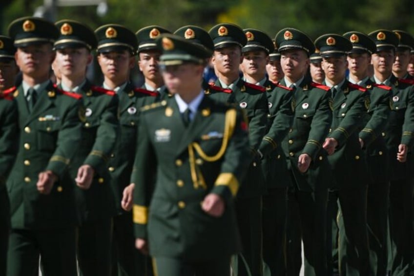 Chinese soldiers march in formation after a wreath laying ceremony at the Monument to the People’s Heroes