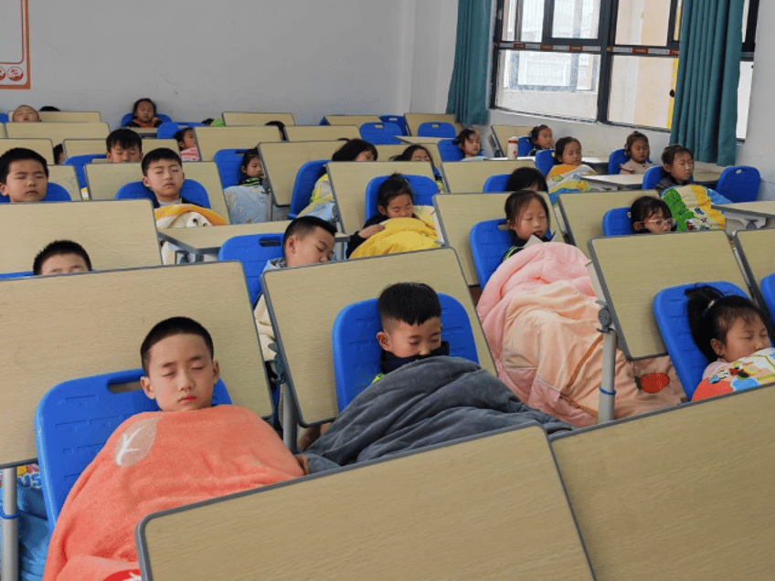 This photo taken with a mobile phone shows students taking noon naps at a classroom of a p