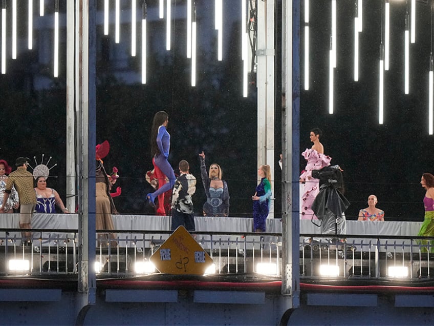 Models walk during a fashion show over the Seine River bridge in Paris, France, at the opening ceremony of the 2024 Summer Olympics, Friday, July 26, 2024. (AP Photo/Andrew Medichini)