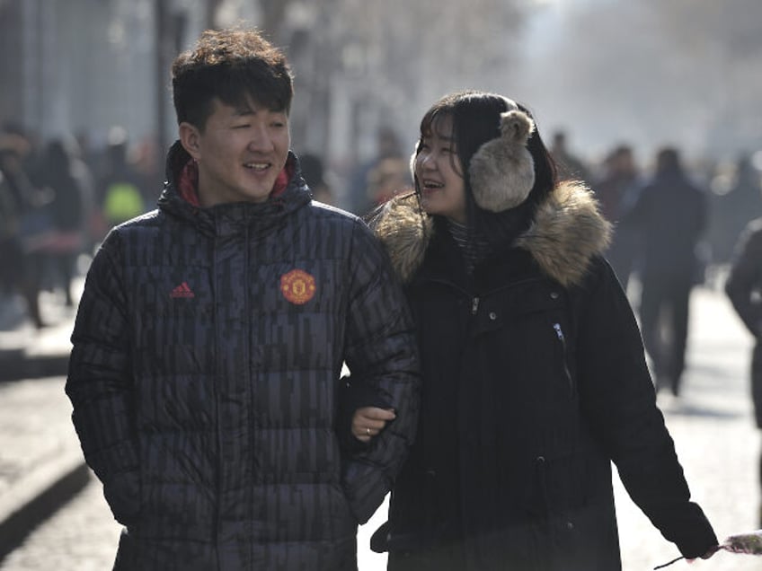 Chinese couples take flowers on Valentine's Day at central street in Harbin city of C