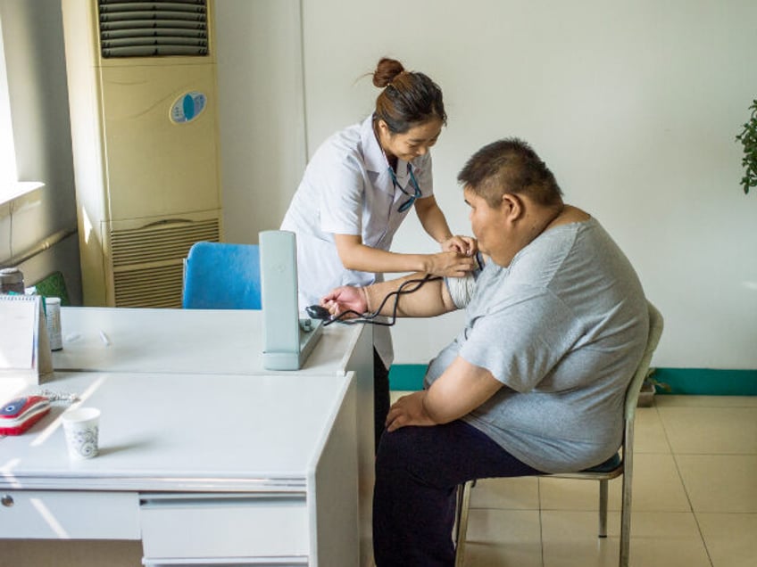 This picture taken on May 25, 2015 shows a nurse taking the blood pressure of an overweigh
