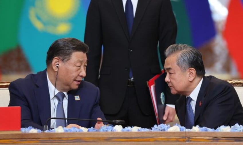 China's President Xi Jinping talks to Foreign Minister Wang Yi during the Shanghai Coopera