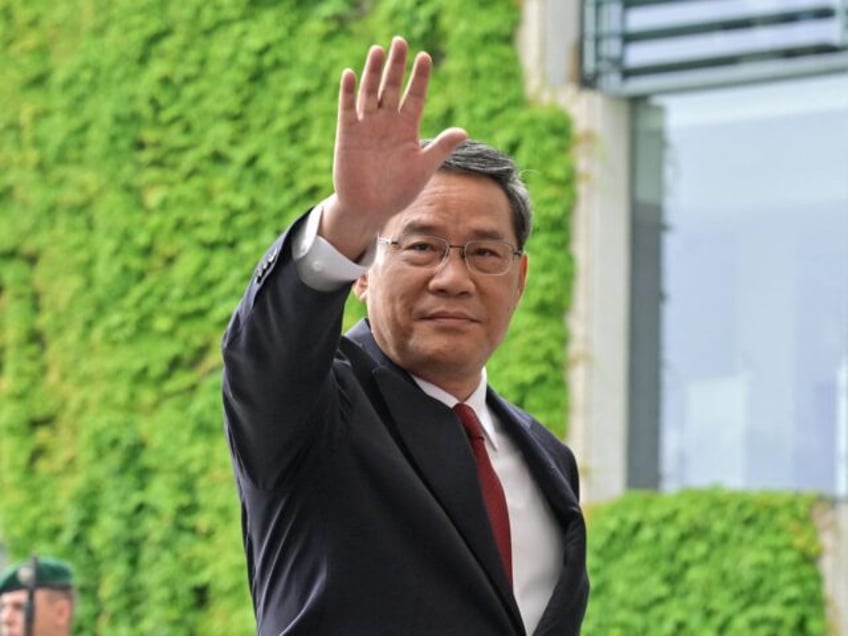 China's Premier Li Qiang waves as he walks back with German Chancellor Olaf Scholz after t