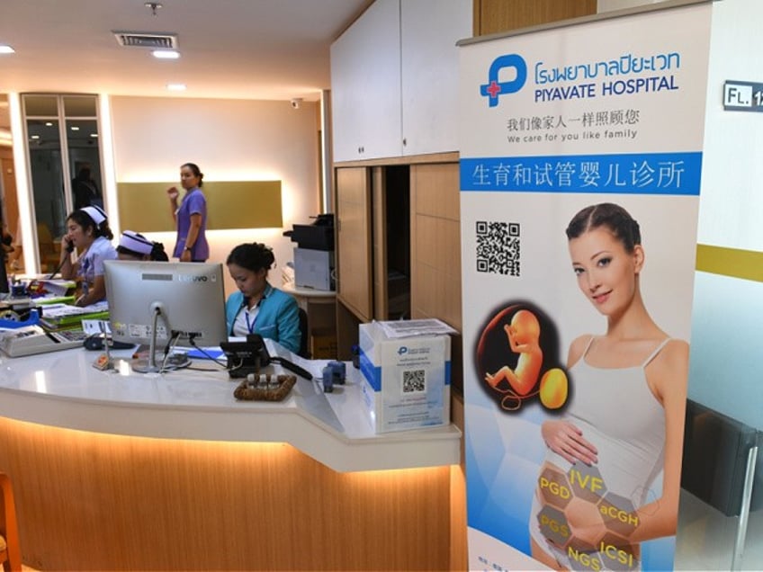 This photo taken on May 17, 2018 shows a poster in Chinese promoting in vitro fertilisation displayed in the lobby of Piyavate Hospital in Bangkok specialising in fertility treatment. - The easing of China's one-child policy was a godsend to Zhang Yinzhe and his wife Xu Mengsha, who had decided they wanted to use in-vitro fertilisation (IVF) to freeze an embryo in the hope of one day having a second child. (Photo by Lillian SUWANRUMPHA / AFP) / TO GO WITH AFP STORY: China-Tourism-Fertility-Health-Thailand-Asia ; feature by Albee ZHANG / Sally MAIRS (Photo credit should read LILLIAN SUWANRUMPHA/AFP via Getty Images)