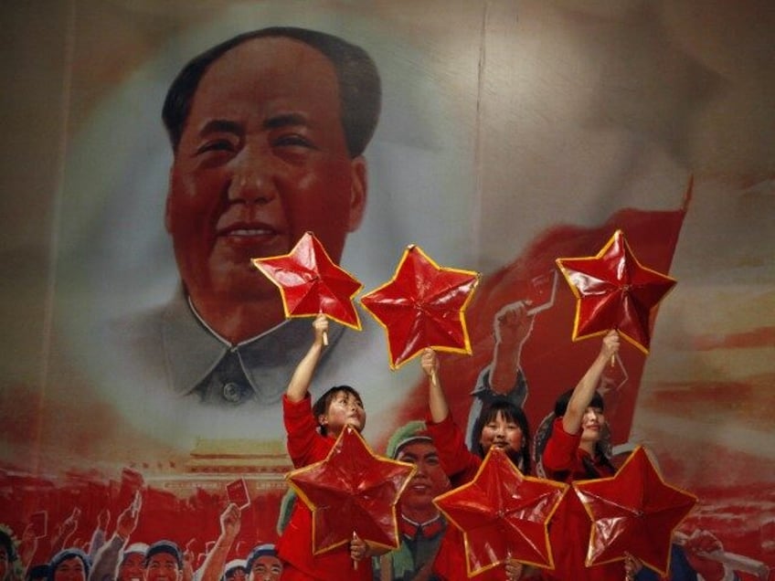 In this file photo taken Monday, May 2, 2011, performers take to the stage near a picture of Mao Zedong at the Red Classic restaurant that capitalizes on nostalgia for China's past in Beijing, China. Friday, Sept 9, 2016 marks the 40th anniversary of the death of Mao Zedong, who …