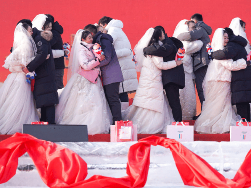 HARBIN, CHINA - JANURY 06: Newly-wed couples holding the mascots 