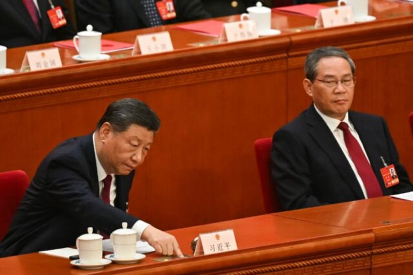 China's President Xi Jinping (L) votes as Premier Li Qiang looks on during the closing ses