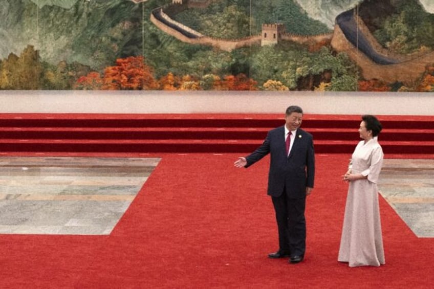 China's President Xi Jinping gestures looking at his wife Peng Liyuan ahead of the dinner