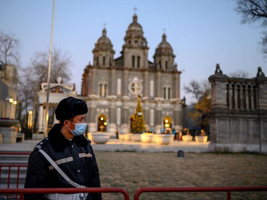 A security guard wearing a face mask stands guard at St. Joseph's Church during a mass on Christmas eve in Beijing on December 24, 2020. (Photo by NOEL CELIS / AFP) (Photo by NOEL CELIS/AFP via Getty Images)