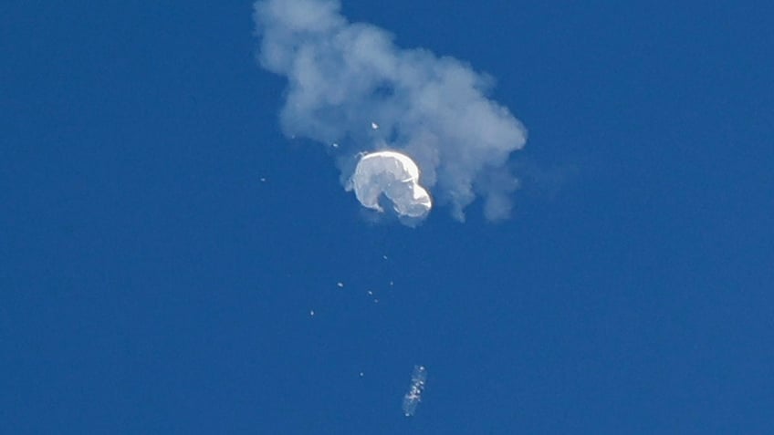 The suspected Chinese spy balloon drifts to the ocean after being shot down