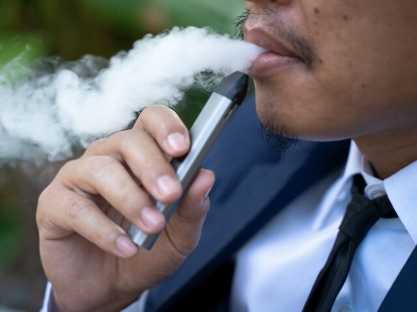 Young male worker smoking electronic cigarette