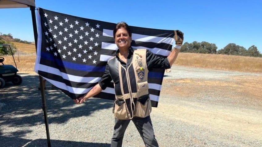 erik estrada posing with back the blue flag