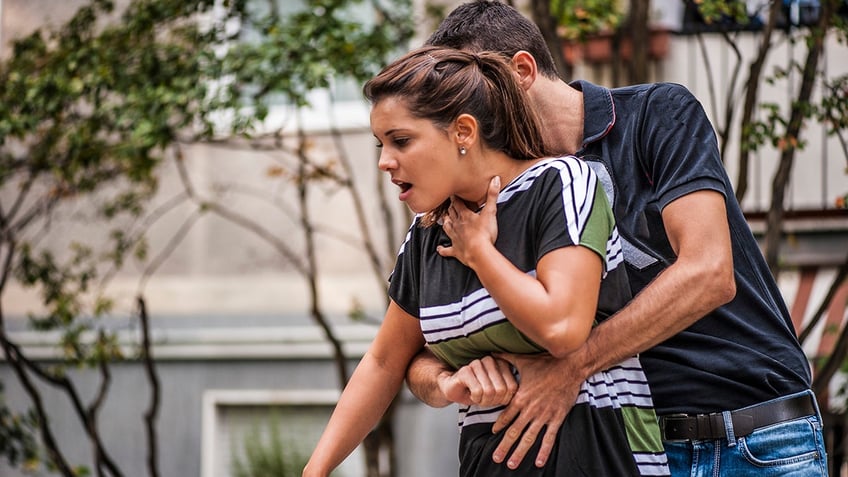 woman is given the heimlich manuever while choking