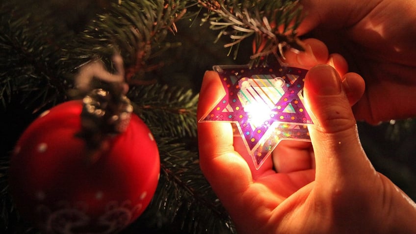 A "Chrismukkah tree" is decorated with Jewish Christmas decoration in a cafe.