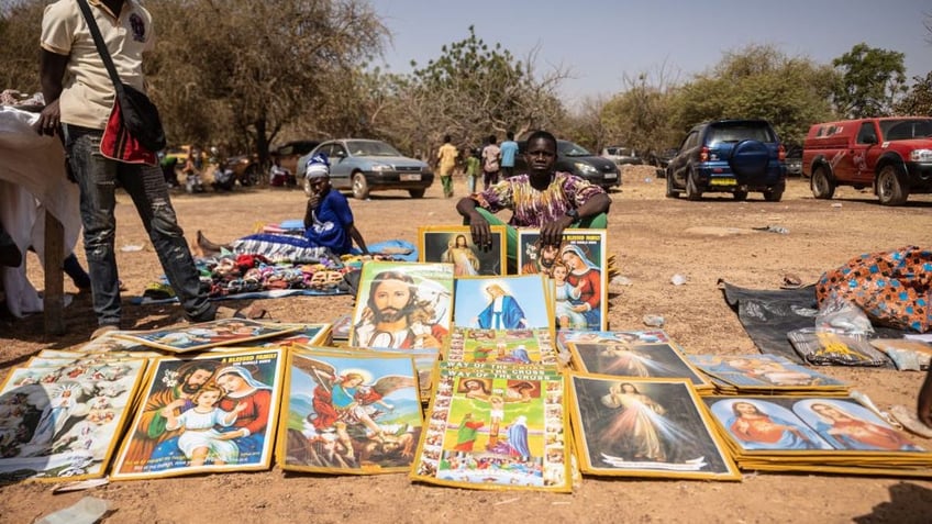 A boy sells objects of piety during a pilgrimage to Yagma on the outskirts of Ouagadougou on Feb. 5, 2023.