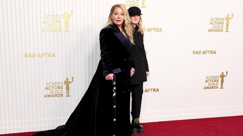 Christina Applegate in all black walks with a cane at the Screen Actors Guild red carpet along with her daughter